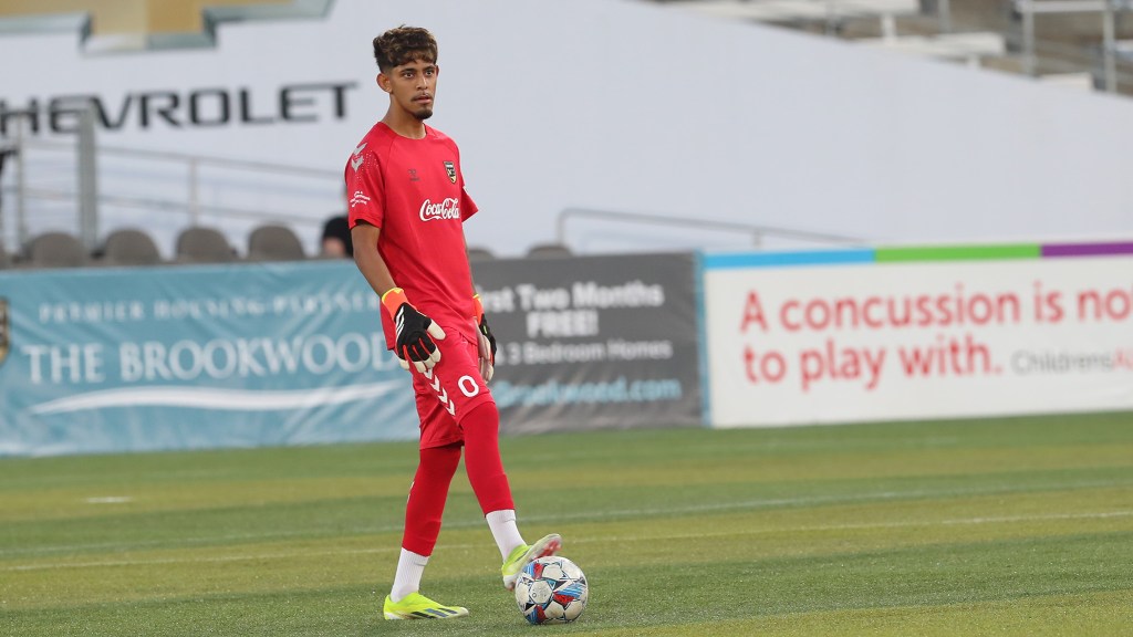 Birmingham Legion FC signs on Fernando Delgado, young goalkeeper, in a red Coca-Cola Legion FC uniform kit with yellow cleats at The Protective Stadium