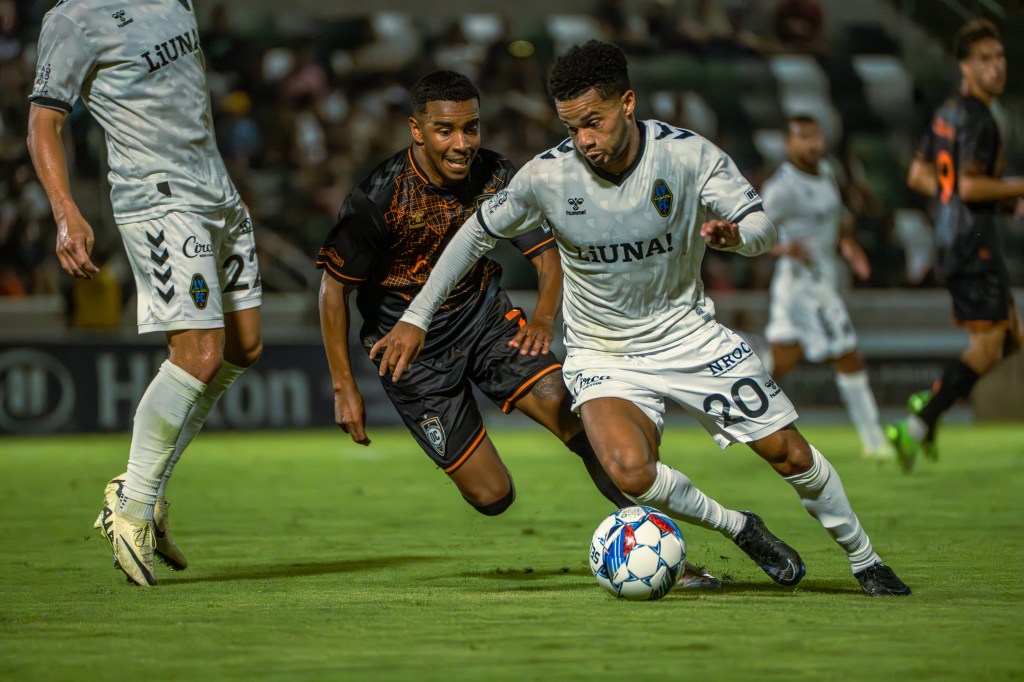 Las Vegas Lights FC defender Shawn Smart challenging an Orange County SC player for the ball