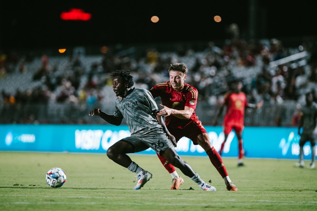 Las Vegas Lights FC midfielder J.C. Ngando battling for a ball against Phoenix Rising FC