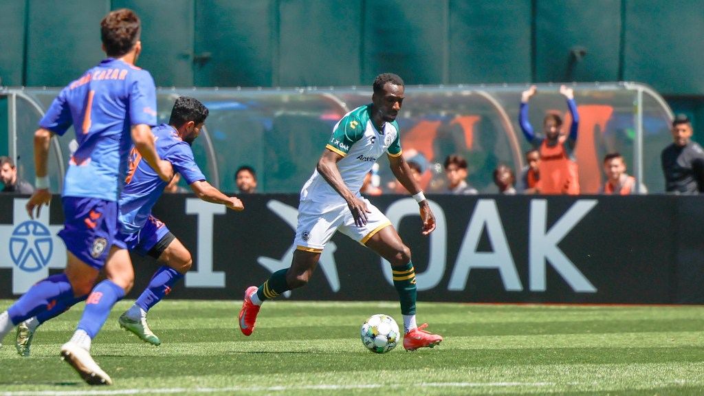 Oakland Roots SC Player, Peter Wilson, in action running with the ball.