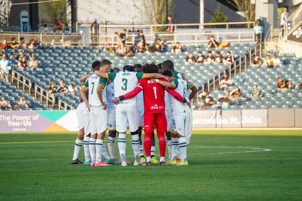 Oakland Roots SC team huddle.