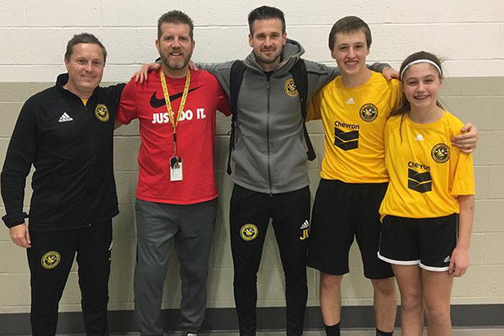 Picture of a Pittsburgh Riverhounds player and coach, attending a gym class at a local school district. 