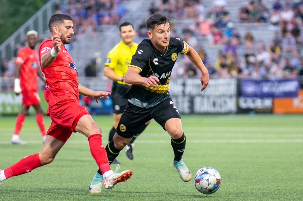 Picture of Danny Griffin and Indy Eleven player running after a loose ball in an attempt to make a comeback during a game at Highmark stadium - Pittsburgh Riverhounds SC