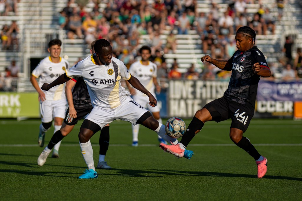 Pittsburgh Riverhounds player Edward Kizza challenges for the ball against Loudoun United FC's Isaiah Johnston at Highmark stadium
