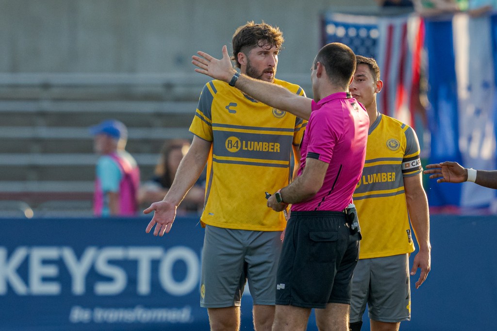 Pittsburgh Riverhounds players Pat Hogan and Danny Griffin protest as referee Elijio Arreguin points toward the locker room after changing his decision to a red card sending off Pat Hogan in the fourth minute of the against Indy Eleven at Michael A. Carroll Stadium in Indianapolis.
