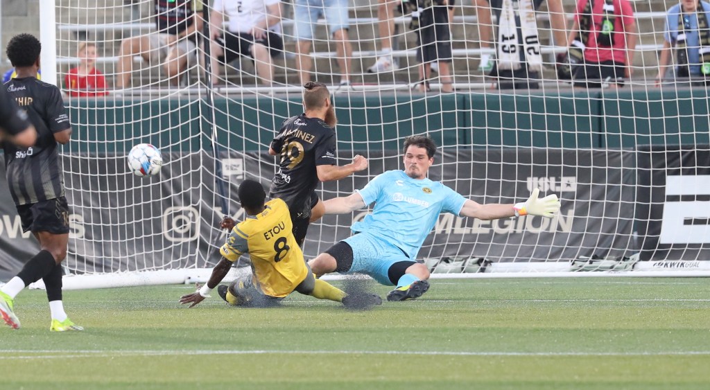 Riverhounds goalkeeper Eric Dick makes a save on Birmingham Legion FC's Enzo Martinez in the Hounds' 3-0 win at Birmingham on Aug. 24, 2024 at Protective Stadium in Birmingham, Ala. (Photo courtesy of Birmingham Legion)
