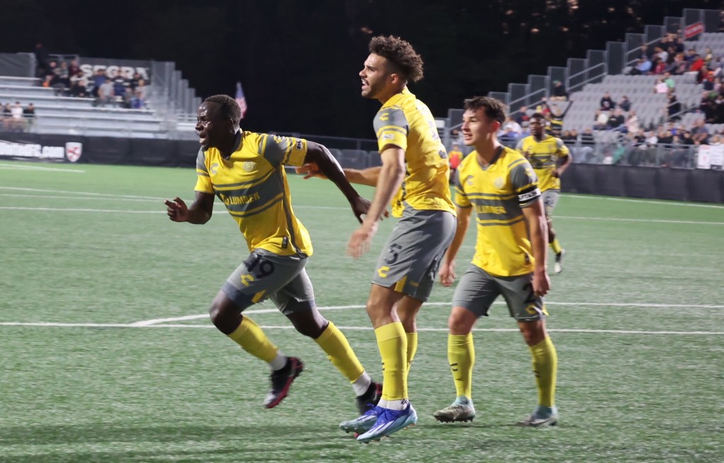 Edward Kizza celebrates his opening goal as Sean Suber and Danny Griffin look on during the Riverhounds' 2-0 win over Loudoun United FC on Oct. 19, 2024, at Segra Field in Leesburg, Va.