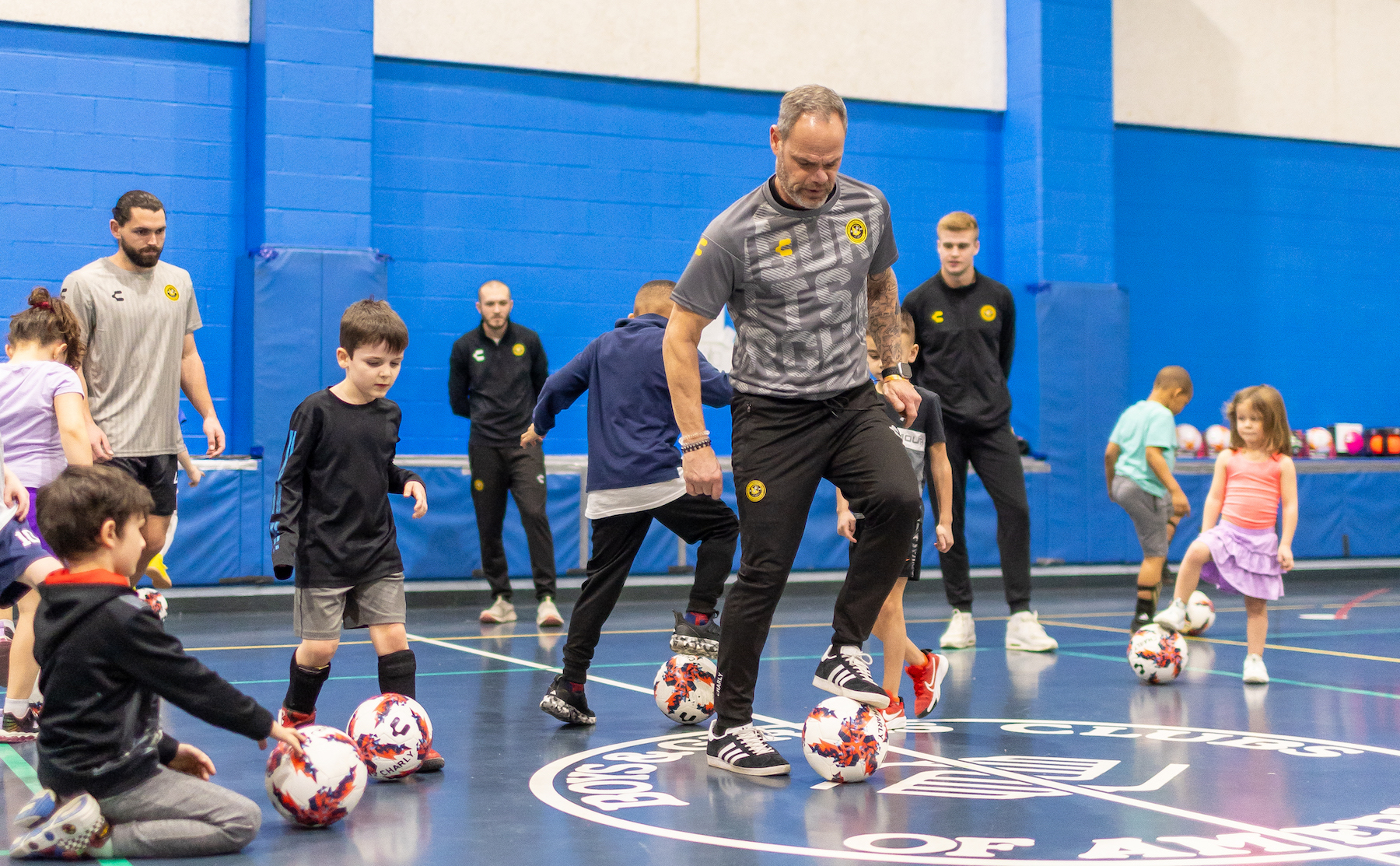 Riverhounds Academy coach Rich Hackenberg instructs children at the Boys & Girls Club of Western Pennsylvania's clubhouse in Pittsburgh's Lawrenceville neighborhood on Feb. 4, 2025, as part of the new partnership between the two organizations. (Photo: Mallory Neil/Riverhounds SC)
