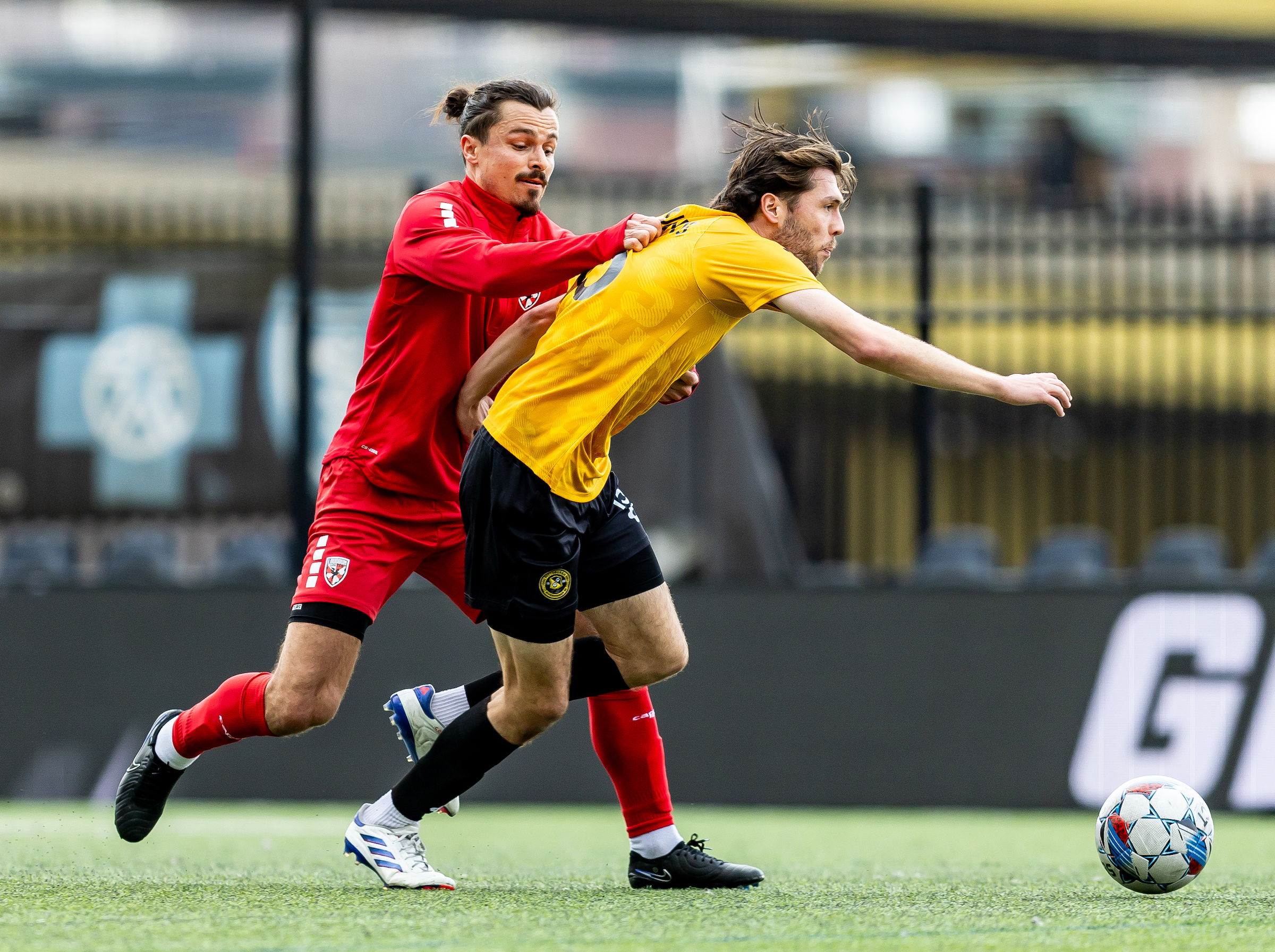 Riverhounds midfielder Bradley Sample gets held back by Loudoun United FC midfielder Florian Valot in the 2025 preseason meeting between the two teams on Feb. 25 at Highmark Stadium. (Photo: Mallory Neil/Riverhounds SC)