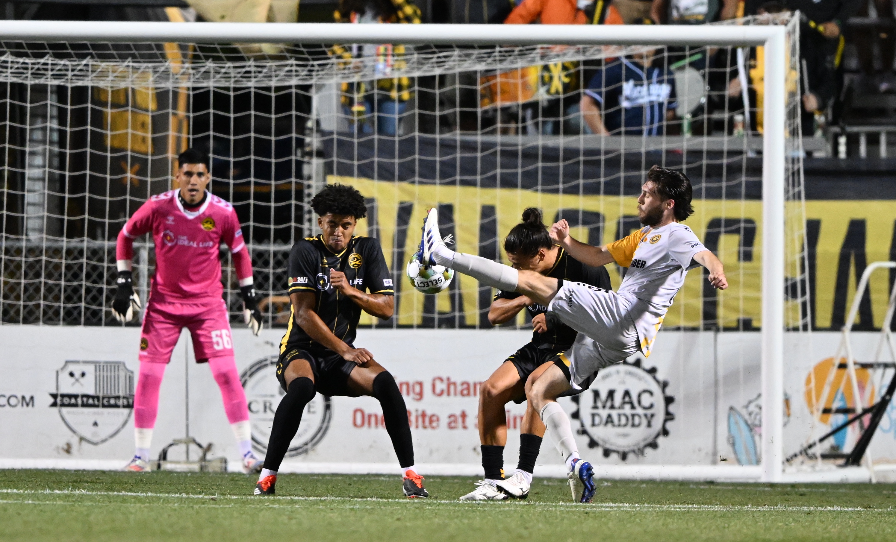 Riverhounds midfielder Bradley sample volleys the ball under pressure from the Charleston Battery's Nate Dossantos and Joey Akpunonu during the teams' match April 12, 2025 at Patriots Point in Mount Pleasant, S.C. (Photo: Charleston Battery)